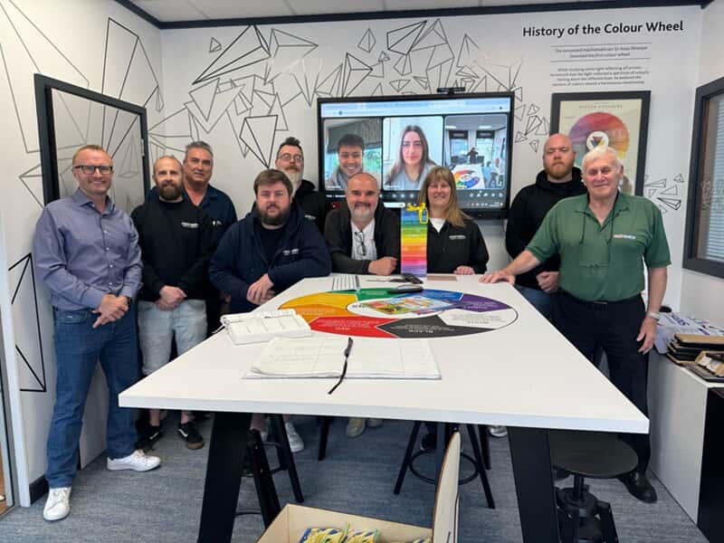 An image of the FASTSIGNS Leeds team in an office meeting.